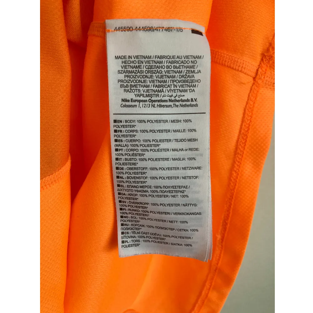 Starkorange löpartopp från Nike med holkärm. Mått i cm: bröstvidd 43; axelbredd 37; längd fram från axeln 61; ärmlängd 10,5.. Sportswear.