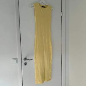 Ribbad långklänning i skönt stretchigt material. Använd en gång. Lite ljusare gul i verkligheten
