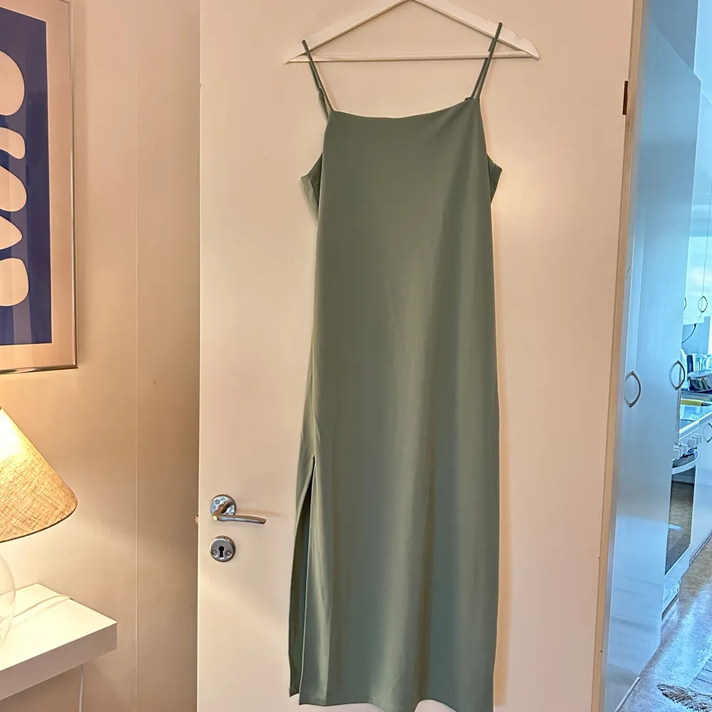 Grön klänning från H&M med slits på ena sidan! Använd fåtal gånger💕 Banden går att justera. . Klänningar.