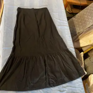 Svart lång kjol med dragkedja och knapp i sidan  Från Kappahl i storlek 36 