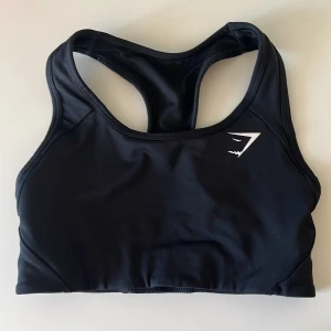 Sport-behå gymshark - Knappt använd. Svart sport-behå från gymshark med brottarrygg.