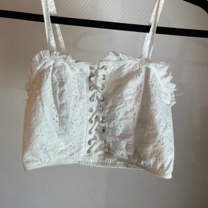 Korsett Topp - Söt somrig topp med snörning. Blommigt mönster i tyget och stretchig rygg. Banden går att justera. 