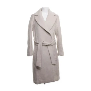 Beige Kappa - Jag säljer min beiga långa kappa då jag inte har någon användning av den då jag har andra kappor. Den är köpt på sellpy och den var redan i väldigt bra skick när jag köpte den! Jag har aldrig använt den,kappan kosta 450kr men säljer såklart billigare