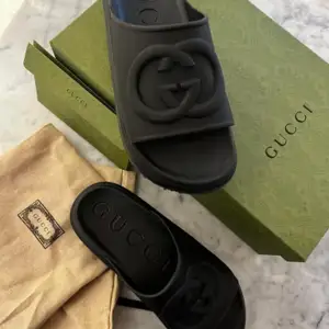 Säljer Gucci WOMEN'S SLIDE WITH INTERLOCKING G. Stl39  Köptes våren 2023 på Guccis hemsida och är aldrig använda pga att när jag testade dem visade sig mina fotvalv vara för höga.  Kvitto, kartong, duffybag allt finns. Nypris 440€=5500kr