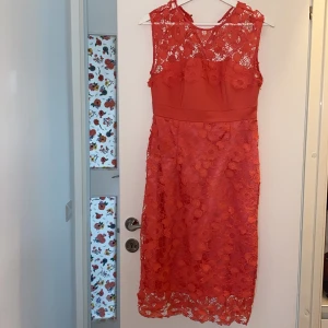 Fin klänning  - Fin klänning som passar till bröllopsfesten eller en middag. Perfekt nu till sommaren med den härliga färgen. Färgen är orange/ rosa / neon färg 