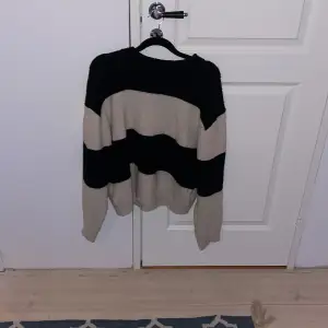 Det här är en stickad tröja i storlek xs men passar mer som s. Jag säljer den för att den inte kommer till användning. Tröjan har beige och svarta ränder. Inte används så mycket och är i väldigt fint skick.
