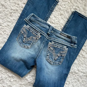Lågmidjade Bootcut jeans vigoss - Ursnygga jeans med hål från vigoss.   Storlek S1/2 Köpta utomlands Har Inga bilder på då de är för stora. Innerbenslängd: 75 midjemått: 36 x2 + mycket stretch. Vill du köpa trycker du på köp nu, jag postar inom 24h