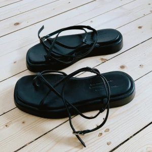 Arket remsandaler  - Fina, som nya - använd fåtal gånger Normal i storleken - 38  Platåsandaletter i mjukt läder med tåögla och smala korslagda fotremmar samt läderklädd sula. Metallspänne.  Mjuk vadderad innersula för bästa komfort. Innersulans höjd: 3 cm.