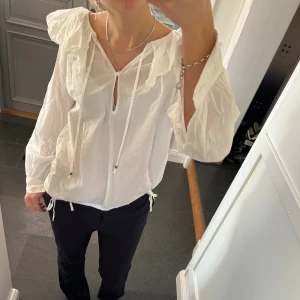 Vit volangblus  - Vit blus med volanger och snörning från Zara i storlek S. Fint skick. Använd gärna köp nu!