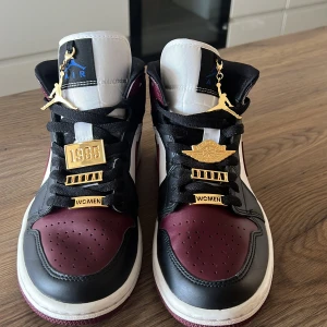 JORDAN 1 ”DARK BEETROOT” MID (W) - Jordan 1 damskor i mycket bra skick, använts endast få gånger. Tillhörande utsmyckningsbrickor ingår ( 8 st.) Nuvarande ny pris 3200kr