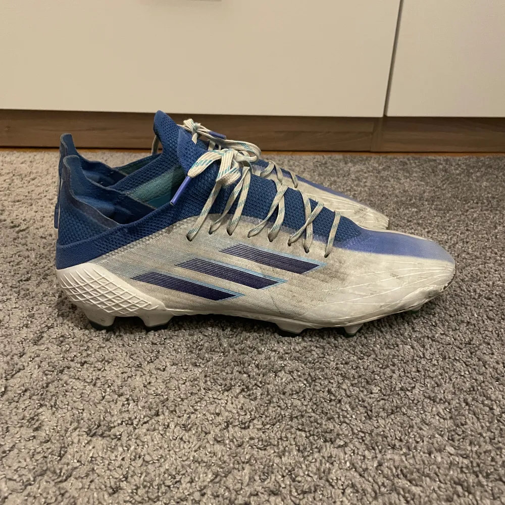 Ett par Adidas Speedflow vit/blå. Storlek 42. Välanvända och har tappat lite i fronten med fungerar väldigt väl att spela i! Lite smutsiga men går att tvätta bort. Därav priset Nypris: 2299  Hör gärna av dig om du har frågor!. Skor.