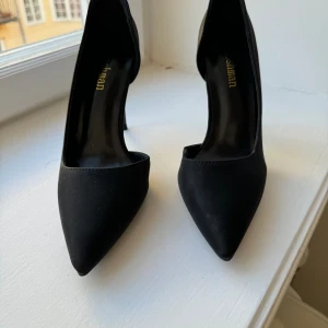 Pumps  - Oanvända pumps med hög klack. 
