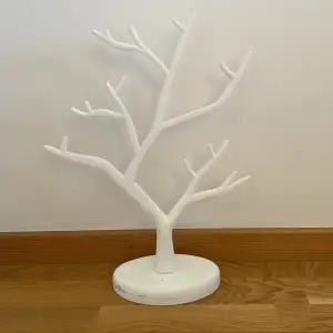 Ett vitt smyckesträd med två delar som man sätter ihop som tyvärr har få skador på sidan men som lätt går att måla över. Perfekt för att hänga sina smycken på.