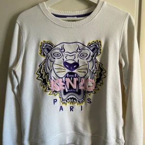 Kenzo tröja - Säljer min vita kenzo tröja som bara hänger i min garderob. Den är använd men i väldigt bra skick. Osäker på storleken då det står L (barn) och jag tror det motsvarar XS/S i vuxen då den passar mig som har S/M. Köparen står för frakten.