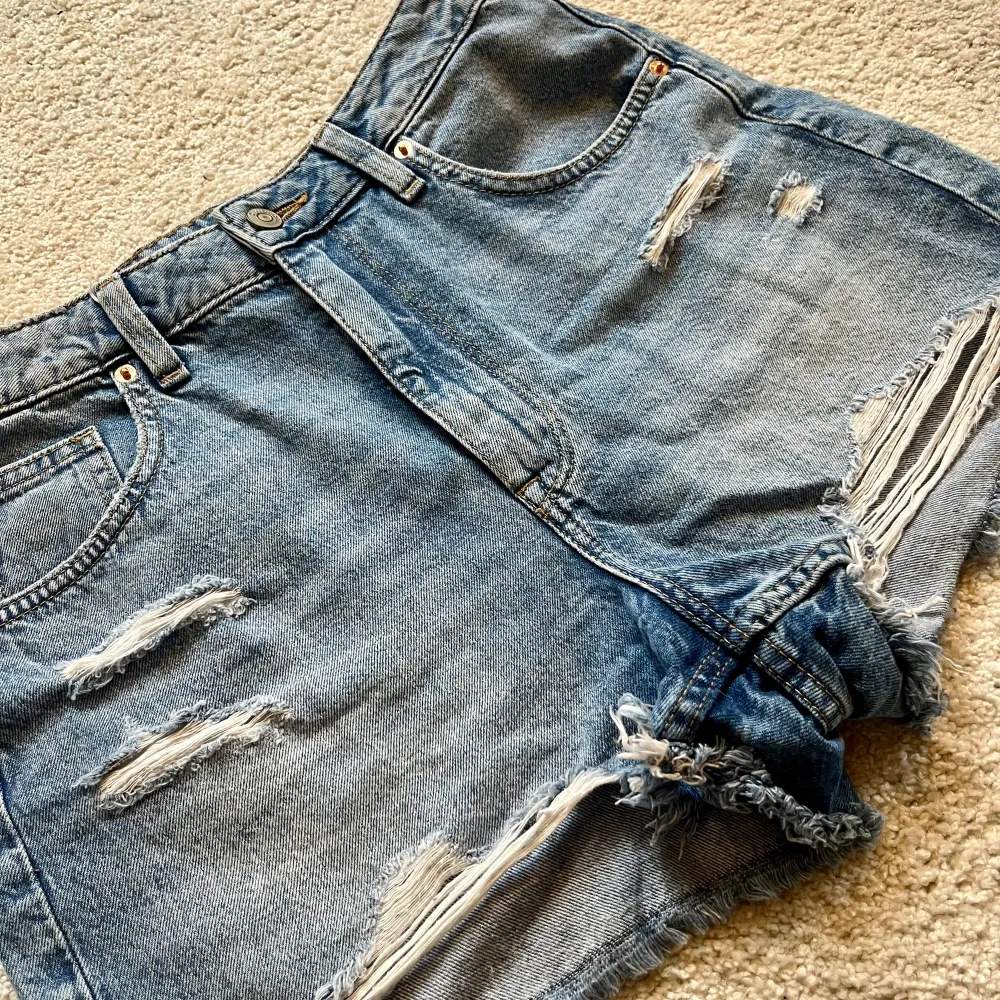 Oanvända jeansshorts med slitningar från HM, storlek M.. Shorts.