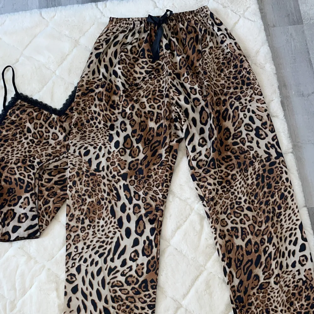 Oanvänd pyjamas, leopard mönster på, linnet och byxorna ingår i priset, strl S/M. Övrigt.