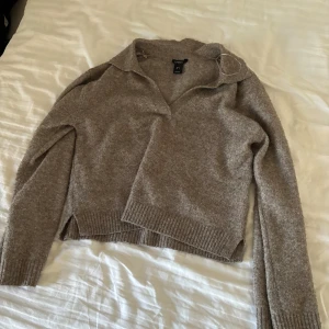 Brun/Beige stickad tröja - Säljer en stickad tröja från Lindex i storlek S, använd några gånger och väldigt skön, perfekt till en vardagsoutfit eller som en tröja som man kan ta över på sommarkvällarna. Ganska nopprig och säljer därför för lågt pris.