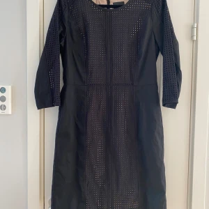Ny Svart hålmönstrad klänning i strl 42 från Inwear modell Cortado - Ny  Klänningen har en beige underklänning som lyser igenom vid hålmönstret.  Mått Över bröstet: ca 51 cm Längd från axeln och ner: ca 97 cm  Klänningen är i 100% bomull,  underklänningen är i 95% polyester och 5% elastan.   Djur o rökfritt hem 