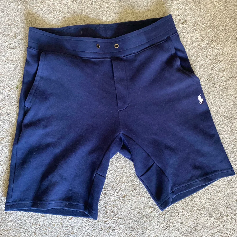 Säljer nu mina mörkblå Polo Ralph Lauren Shorts inför sommaren då de har blivit för små. Shortsen är i storlek M men är små för sin storlek. Inga defekter på själva shortsen men de har inga snören kvar. Utgångspriset är 299 men priset kan diskuteras!. Shorts.