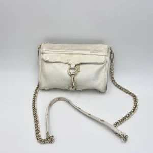 Rebecca minkoff väska - Äkta vit Rebecca minkoff väska! Perfekt till balen eller studenten, Nypriset låg på ca 2500kr! Lite sliten och smutsig (se bilder) därav priset!