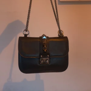 Valentino glam look bag - Svart valentino väska i modellen glam look medium. Alltså mellan storleken som är den perfekta handväskan där man får plats med mobil, nycklar, plånbok och mycket mer. Den är i bra skick och har inga missfärgningar. 