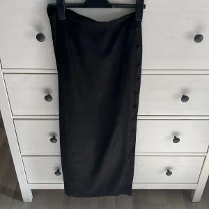 Vintage sommarkjol - Vintage sommarkjol från indiska med snygga klädda knappar på sidan som man kan knäppa upp för större/ mindre slits. Storlek c38 (Small, Medium) Superskönt och svalt material perfekt för sommaren. Köparen står för frakt, finns katt i hemmet!