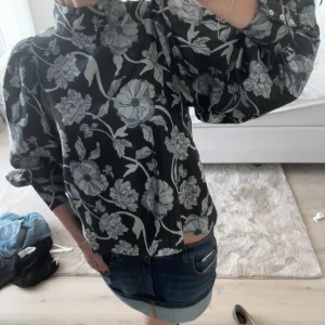 Blommig blus  - Blommig blus i blått och svart från STOCKHO LM . Puffiga armar. 