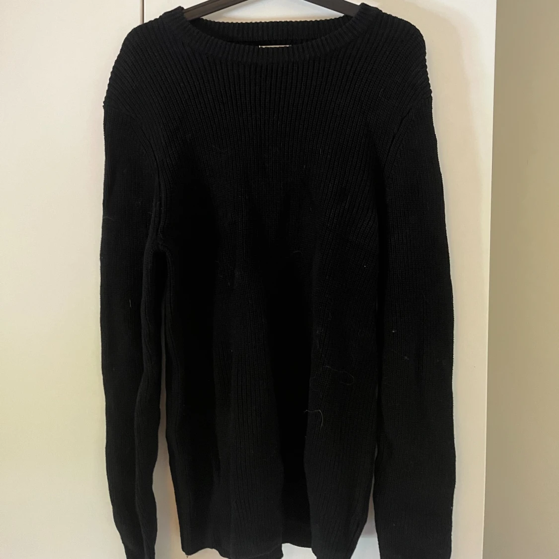 En helt vanlig svart stickad tröja 