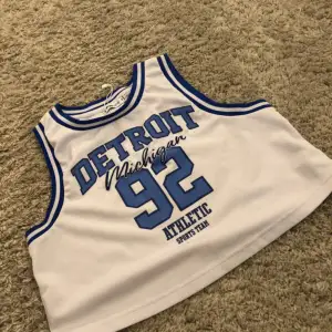 White basketball top with blue text