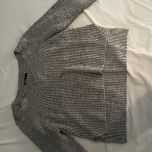 Stickad tröja  - Grå stickad tröja, använd men i bra skick, har slits på sidorna av tröjan  Om du vill ha fler/bättre bilder så är det bara att skriva ett meddelande så skickar jag gärna!