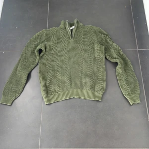 Grön stickad haf zip tröja - Tröjan är 10/10 i skick. Helt oanvänd. Den är stickad och varm. Den är haf zip. 146-152 är storleken. Passar till vintern.