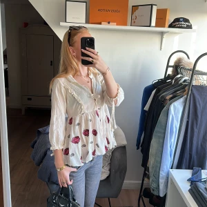 Odd Molly blus  - Lite äldre super söt blus från Odd Molly.😇Väldigt detaljerad med rosor, volanger och rosetter🎀 Finns knappar i princip hela vägen upp. Färgen är originellt benvit, alltså är den ej missfärgad😊Tunt material, perfekt till sommaren!😻💕