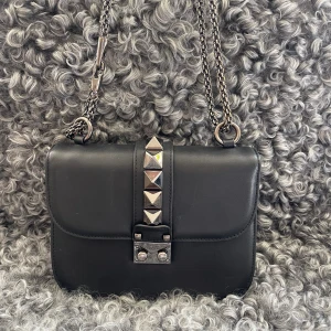 Valentino Väska -  Nu är det dags att sälja min super snygga svarta Valentino väska med silver detaljer. Fungerar jättebra för fest samt vardag. Har haft den i några år men är väl omhändertagen. Skriv för frågor🌸🥰🙌🏻 