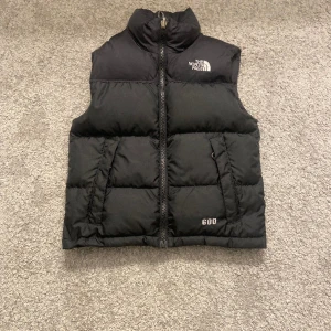 The North face väst  - The North face väst svart.Två fickor utanpå och en ficka inuti.Säljer för 500 kr.Köparen står för frakten.