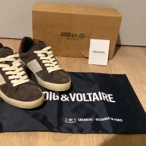 Zadig Voltaire skor - Tvär feta grå bruna Zadig voltiare skor i storlek 41, skick 9,5/10 nästan aldrig använda. Allt på bilderna medföljer. GÅR INTE ATT KÖPA HELT NYA! Skriv gärna vid funderingar!