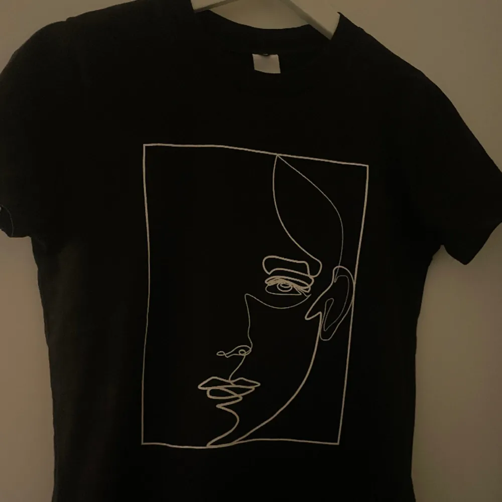 Sjukt snygg svart t-shirt med vitt ansiktstryck från MQ i XS😍Nyskick och använt ett fåtal gånger! Nypris: 400 kr mitt pris 130 kr + frakt💕. T-shirts.