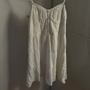 Vit klänning med blom mönster  - Klänningen är andvänd 1 gång och är i perfekt skick. Det går att shystera banden. Klänningen är i storlek L men är liten i storlek , jag bär vanligtviss S - M och den sitter perfekt ! 