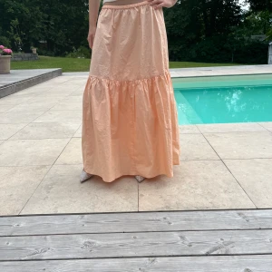 Orange långkjol - ENDAST INTRESSEKOLL! Intressekoll på min fina långkjol som tyvärr inte kommer till användning längre. Storlek M men sitter snyggt lite oversized på S. 