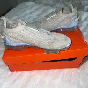 Nike vapormax  - Vita Nike skor. Köpta 2020 för ca 1500kr. Denna modell finns ej att köpa i butik längre. Spännerna och snörningen fungerar som den ska. Några enstaka färgfläckar och lite missfärgning under. Ingår tvätt lappar och skokartong. Pris kan diskuteras. 