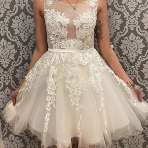 Vit klänning  - Säljer denna drömmiga klänningen i storlek 34. Broderi, knytning i ryggen och lite glitter i tyget 💗 I mycket fint skick. Perfekt till avslutning, bröllop eller midsommar. 🤩Modellen är 170 cm lång. 