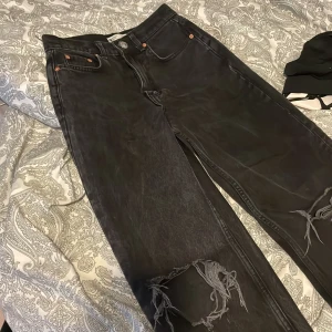 Jeans - ett par jeans med hål i knäna, straight fit