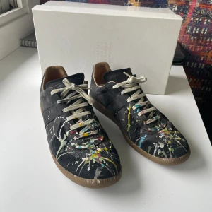 Maison Margiela skor - Maison Margiela Gats med paint splatter i storlek 44. Skorna är i använt skick men är väl omhändertagna. Jag har lagat skorna i hälarna. Kartongen och skopåsar fås med. 