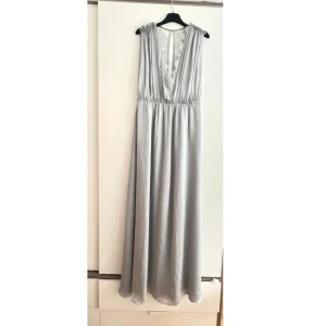 Satin kläning  - Oanvänd Grå/ljus blå satin kläning från hm i storlek 38. Perfekt till högtidliga tillfällen 