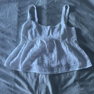 Sommartpp - Gullig sommartorp från Nelly med öppen rygg och rosett i linne liknade material. Aldrig använd innan, endast provad Slutsåld på hemsidan. Nypris 299kr, säljer för 200kr 