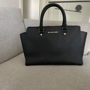Svart Michael kors handväska  - Super fin och elegant, rymlig plats, fem mindre fickor i väskan. Lagom bra skick