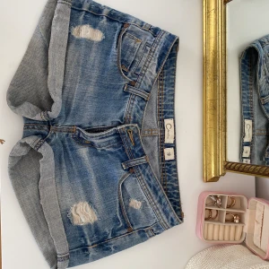 Lågmidjade jeans shorts - Blåa jeansshorts med lite hål. 