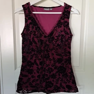 Rosa blommig topp - En rosa topp med svarta blommor av velour/velvet med fina spets detaljer. Från lindex i storlek 38.