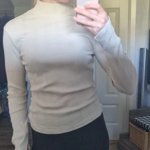 Topp - Beigevit tröja med slitsärmar. 