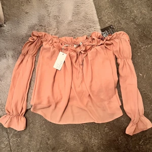 Blusa off-shoulder  - Från Nelly. Lappen sitter kvar. Storlek S Aldrig använd 