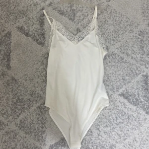 Body  - Säljer denna supersköna body i så fint material oxh med spetsdetaljer. Aldrig använd så helt ny!!